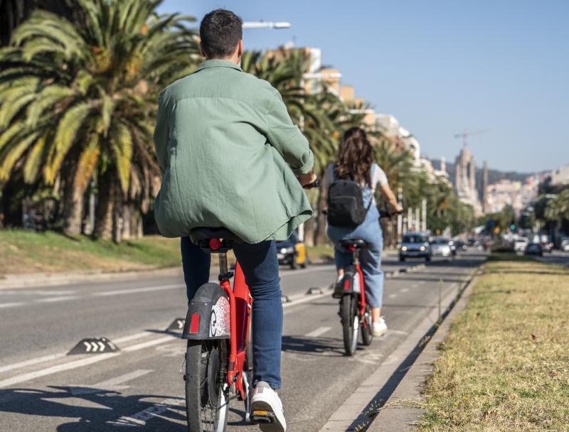 Parella d'amics pedalant en Bicing a la Sagrada Família